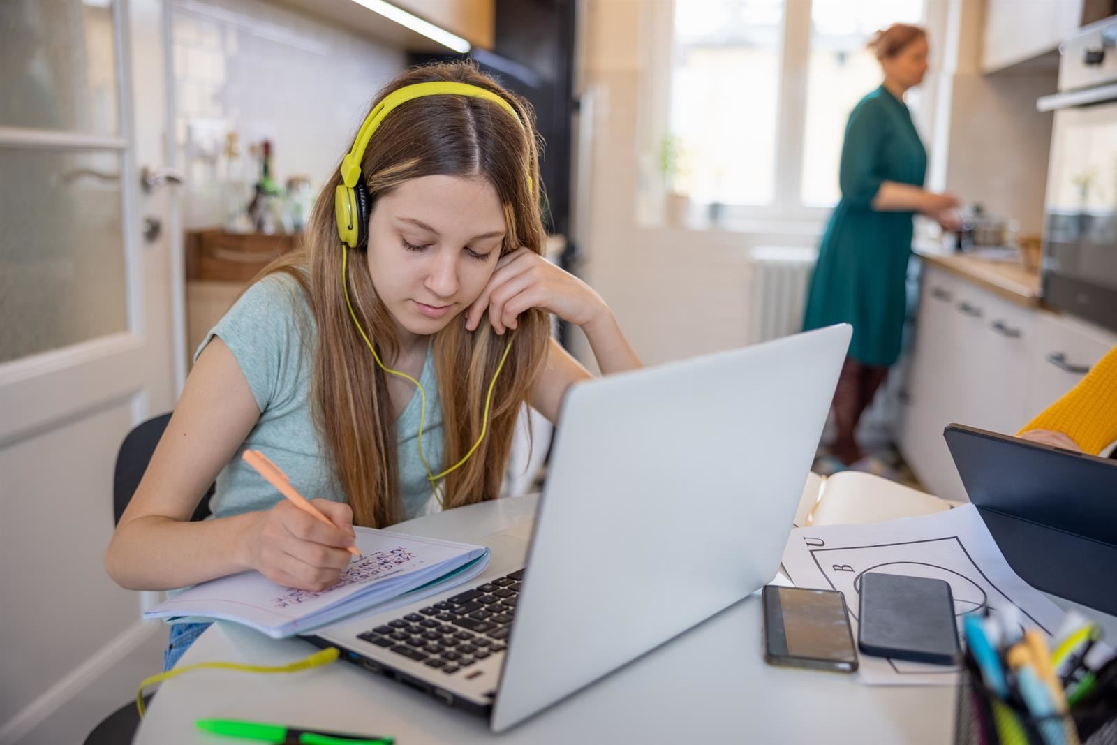 A student at her laptop in her kitchen